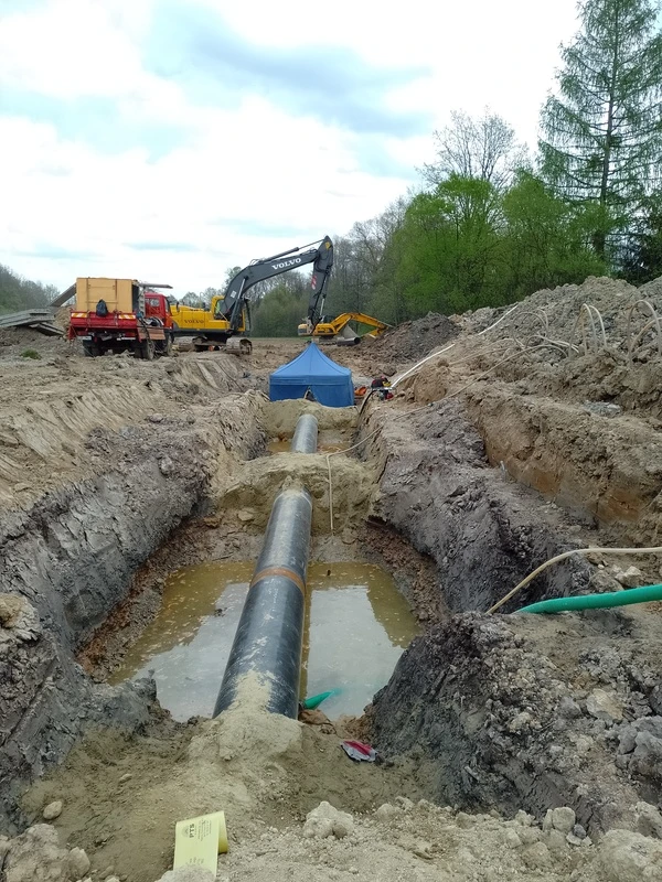 Spawacz Weld-Gaz w pełnym rynsztunku ochronnym wykonujący precyzyjne spoiny na zaawansowanej instalacji przemysłowej wewnątrz hali.